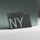 A black business card with large NY text and address details leaning against a modern corrugated backdrop. Perfect for print mockups, graphic design and branding.