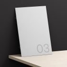 A minimalist print mockup featuring a sleek white book cover with the number 03, against a black and white background, suitable for graphic design projects.