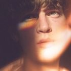 Close-up of a person's face in warm light with a rainbow reflection. Ideal for graphic designers seeking photo effects for digital design assets.