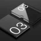 Packaging mockup featuring a sleek black book with a transparent plastic sleeve displaying bold numeral 03. Ideal for graphic designers and packaging design projects.