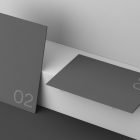 Two dark grey poster mockups leaning and laying on a white surface with the number 02. Perfect for graphic designers creating print or billboard mockups.