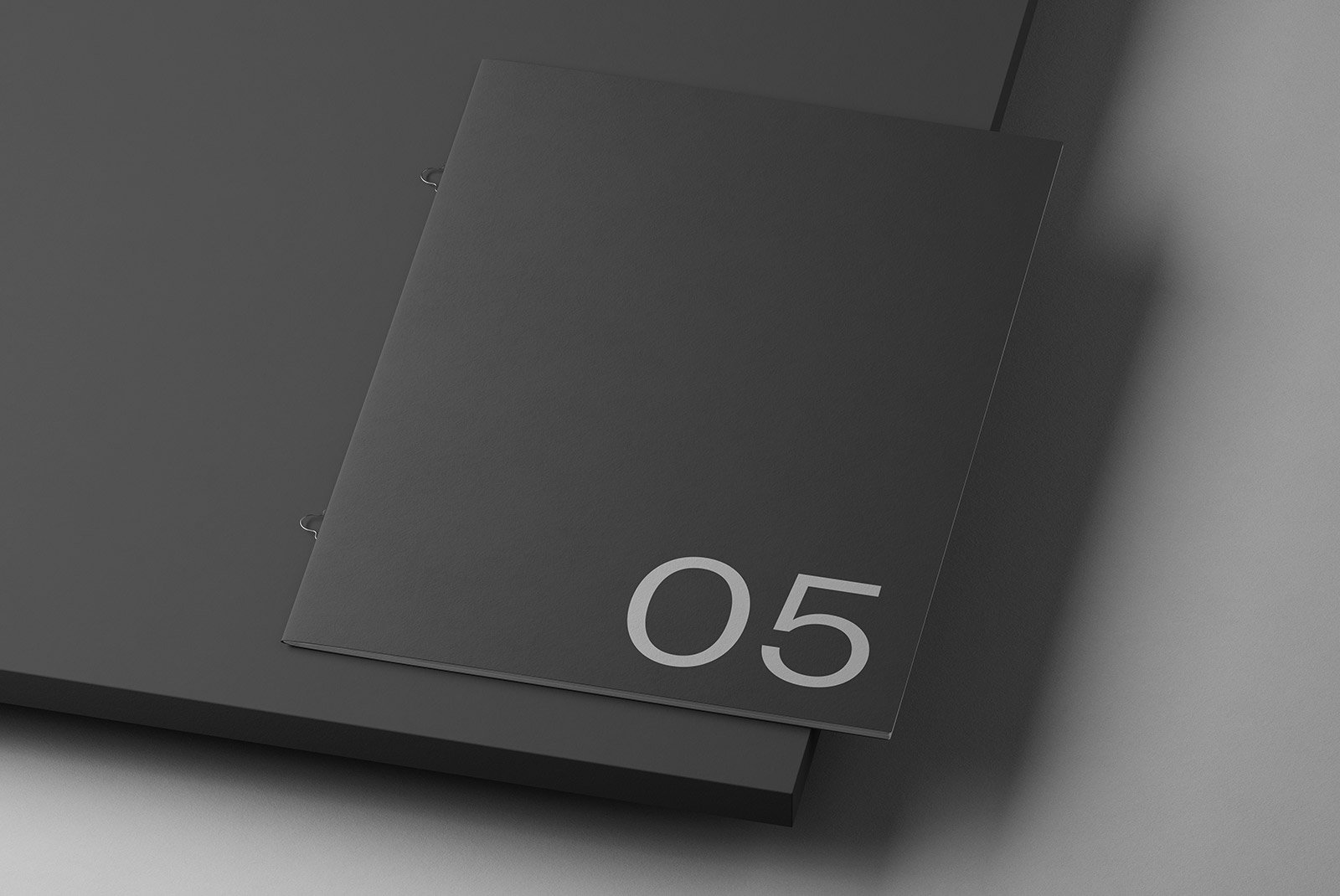 Black minimalistic booklet with the number 05 on the cover suitable for print mockups from a digital assets store for graphic designers.