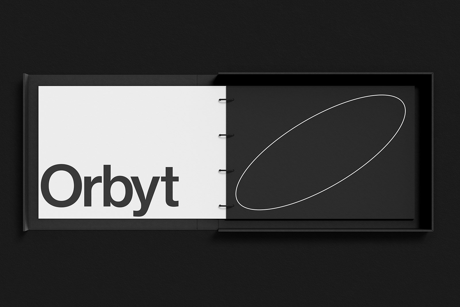 Top view of a black and white packaging mockup with the logo text Orbyt on a white background and a geometric design on a separate black page.