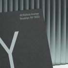 Realistic print mockup featuring a black card with NY letters and address text. Ideal for graphic designers creating business cards or print materials.