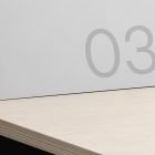 Minimalistic white brochure on wooden surface with number 03. Ideal for brochure mockups, print design, and graphic design resources for designers.