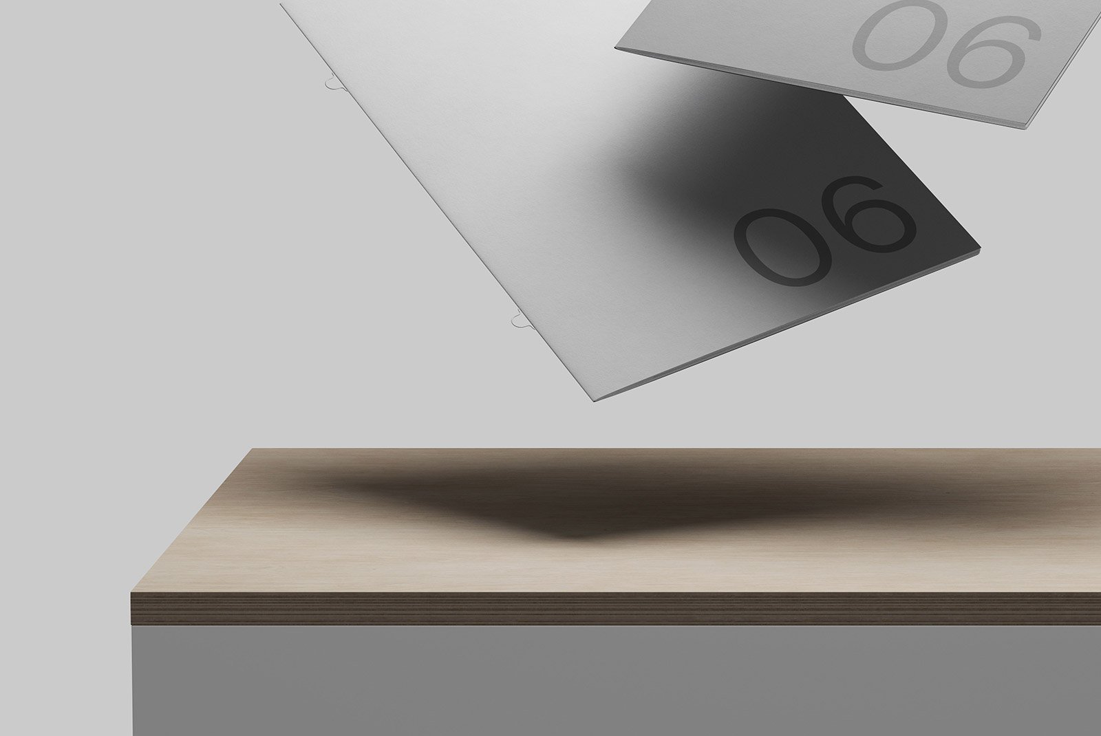 Grey cards with the number 06 hover above a wooden surface. Suitable for print mockups and graphic design projects. Ideal for graphic designers seeking clean imagery.