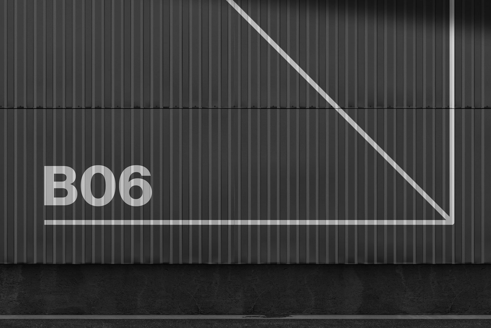 Billboard mockup featuring a textured gray metallic wall with geometric lines and B06 text for graphic designers' digital asset store.