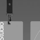 Lanyard and badge mockup hanging on a gray background showing black straps and metal clips ideal for branding, print mockups, ID cards, and corporate design