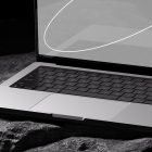 Close-up of a laptop keyboard and part of the screen displaying a curved white line on a rocky surface. Suitable for tech mockups, graphic designers.