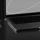 Minimalist tech mockup featuring a sleek modern laptop partially open, highlighting the keyboard and charging cable, ideal for device presentation templates.