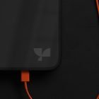 Mockup of a smartphone with an orange charging cable on a dark background. Ideal for tech mockups, digital asset store for graphic designers.