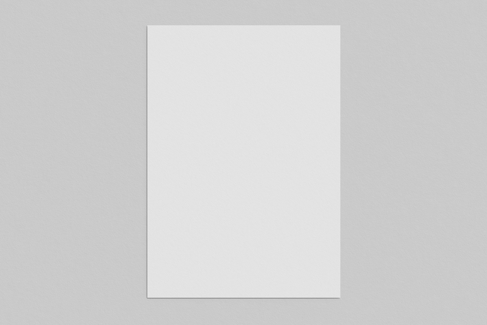 Flat lay of a blank white sheet of paper on a grey background ideal for print mockups poster mockups and graphic design presentations by graphic designers.