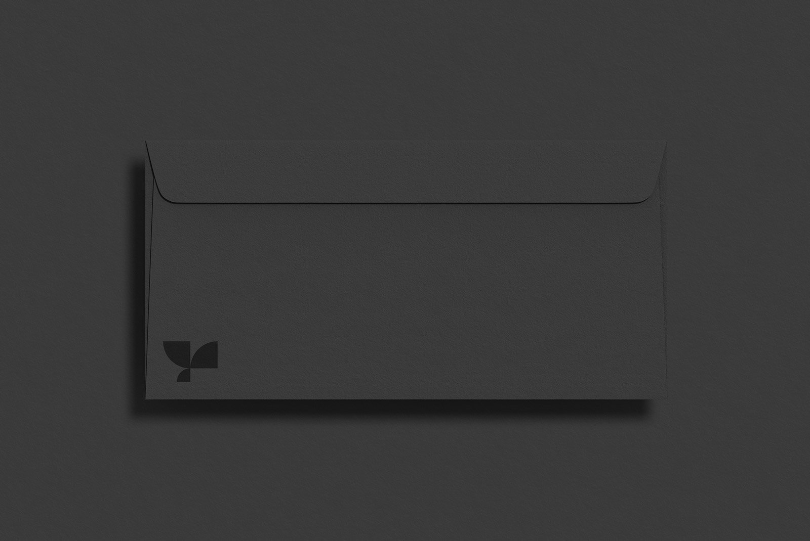 Black envelope mockup on a dark background suitable for graphic designers looking for minimalistic print mockup resources for branding and stationery designs.