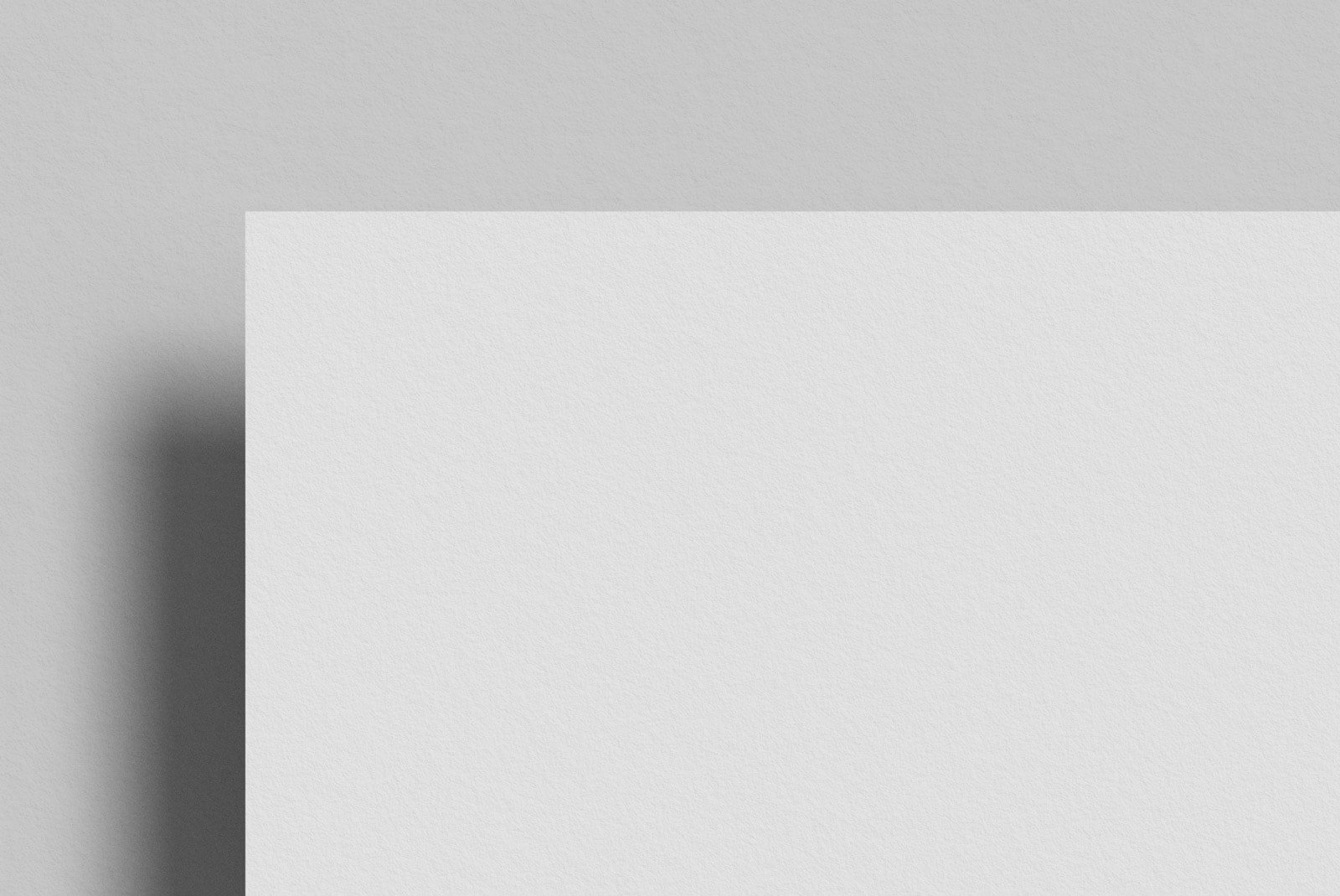 Minimalist print mockup featuring a close-up of the edge of a white textured paper against a gray background; ideal for graphic design projects.