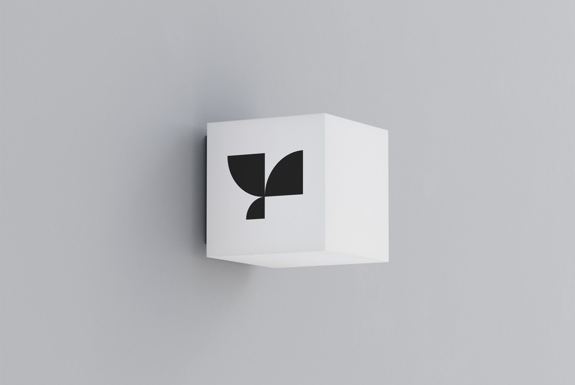 Wall-mounted signage mockup featuring a minimalist black and white geometric logo on a cube, ideal for graphic designers seeking branding design visuals.