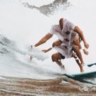 Surfer riding a wave with creative Photoshop effect applied, blending textures of water and sand; perfect for graphics, Photoshop effects or print mockups.