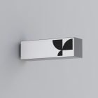 Packaging mockup template showing a minimalist rectangular box with modern black geometric design on a light grey wall. Ideal for graphic and print designers.
