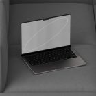 Modern laptop computer displaying blank screen on gray cushioned surface. Ideal for tech mockups, digital product presentations, graphic design resources.