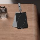 Clear glass cup and two rectangular swatch cards with an oval design on a wooden surface. Mockup suitable for print and packaging design, graphic designers.