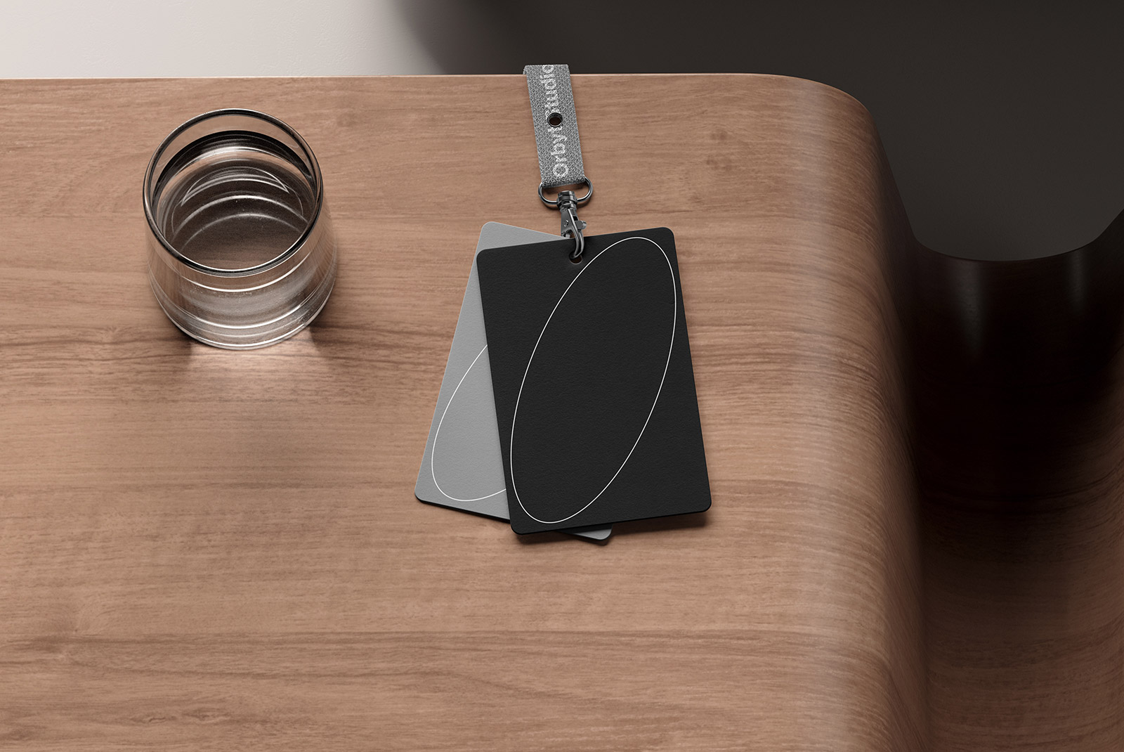 Clear glass cup and two rectangular swatch cards with an oval design on a wooden surface. Mockup suitable for print and packaging design, graphic designers.
