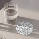 Glass on modern table with stylish coaster design featuring the text Studio ideal for graphic designers digital assets print mockups branding presentations