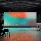 Digital billboard mockup in an airplane hangar with abstract graphics on the screen. Ideal for showcasing graphic design, print mockups, and tech mockups.