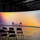 Gradient backdrop display for conferences and presentations in a modern indoor setup with chairs and table. Perfect for billboard mockups and digital presentations.