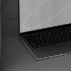 Modern tech mockup featuring a sleek laptop with a blank screen positioned on a gray couch ideal for showcasing graphic designs and tech products for designers.