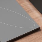 Gray book cover mockup with a minimalist white oval design on wooden table suitable for print mockups and graphic design projects.