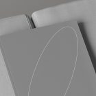 Minimalistic print mockup showing a grey hardcover book with a thin white line design lying on a grey textured sofa. Perfect for graphic designers.